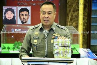National police chief Pol Gen Somyot Poompunmuang shows bundles of cash totalling three million baht which he is paying to police detectives as a 